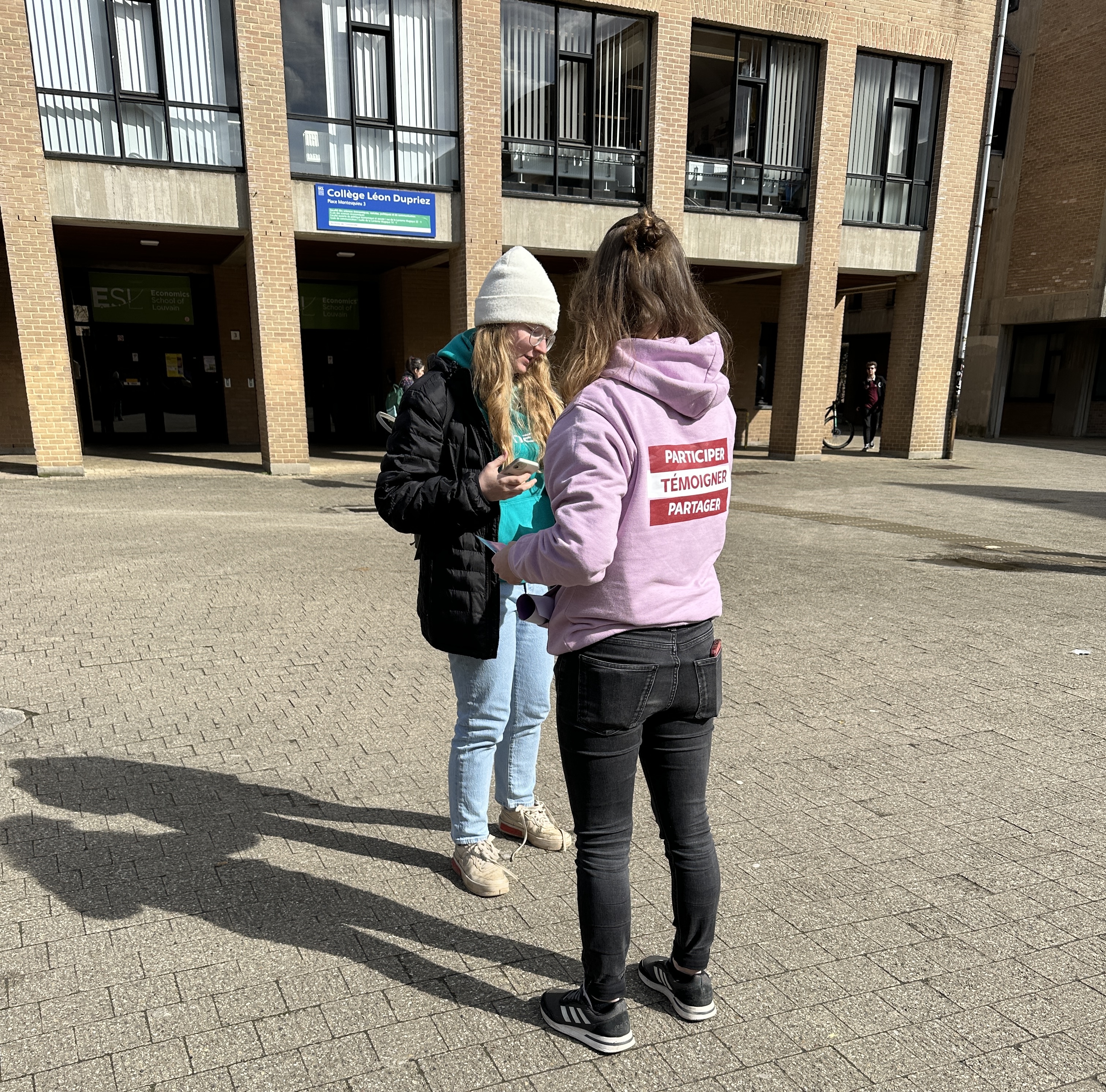 Ambassadrice échangeant avec des étudiantes devant un bâtiment universitaire