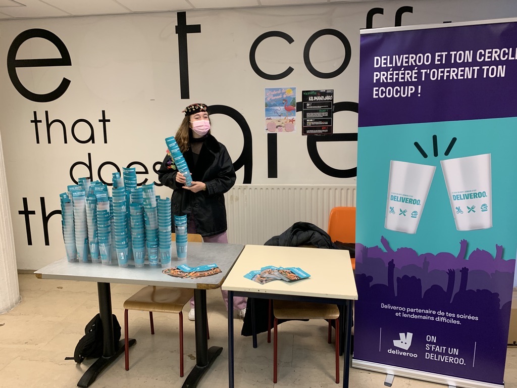 Stand Deliveroo sur un campus, piles d'écocups et roll-up